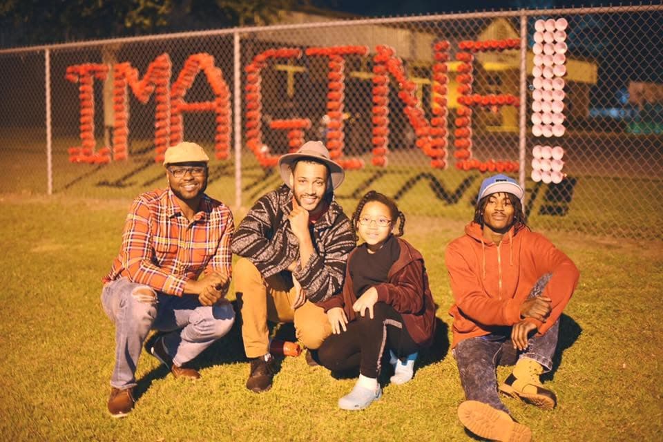 Group at golden hour in front of IMAGINE spelled in red cups