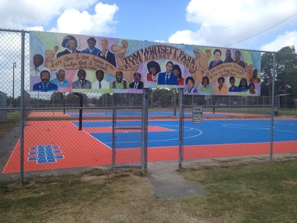 Tom Whitsett Park Black History Memorial mural on a chain-link fence at the basketball courts.