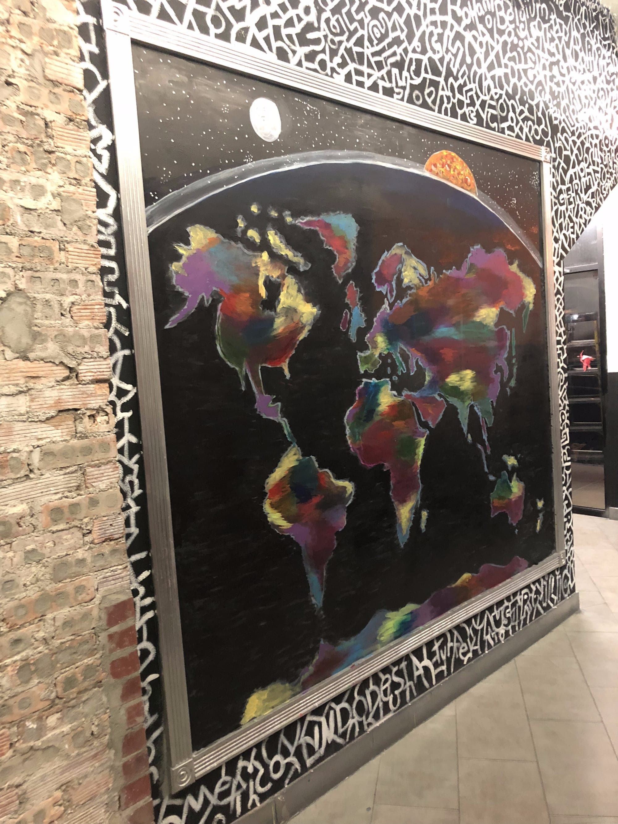 Large-scale world map mural painted on a wall.